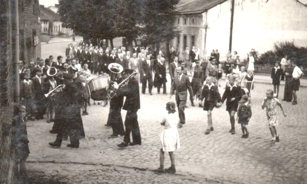 Zorganizowana grupa osób zmierza do sali kinowej na okolicznościową uroczystość. (kolekcja J.Rosina)