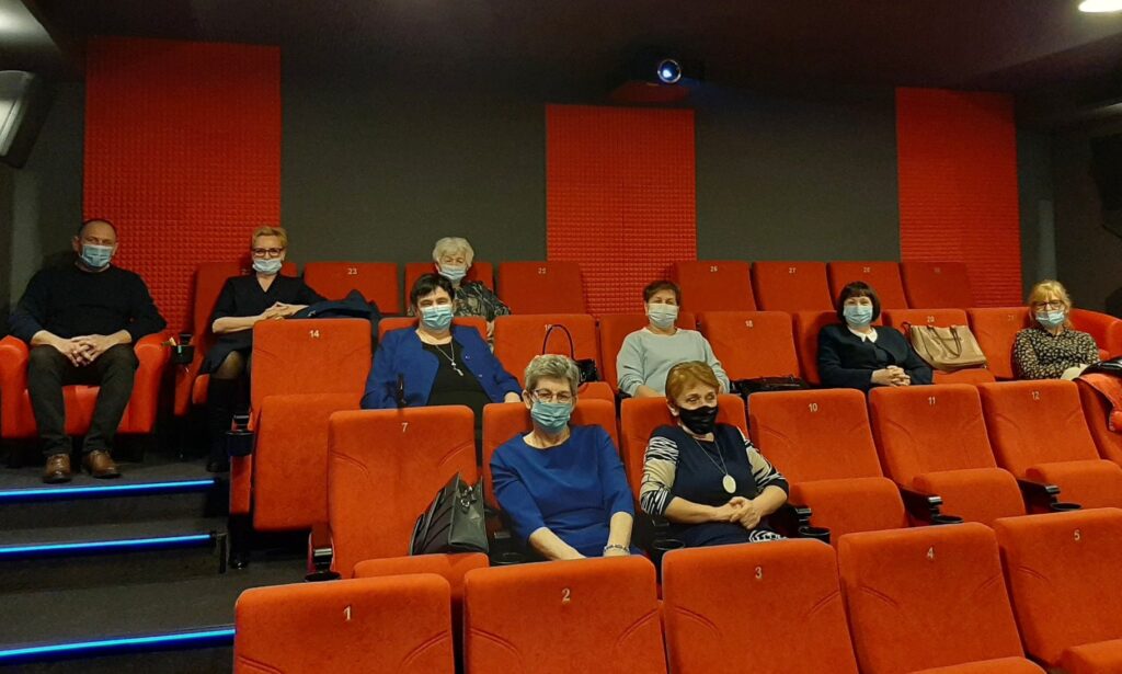Osoby siedzą w sali kinowej