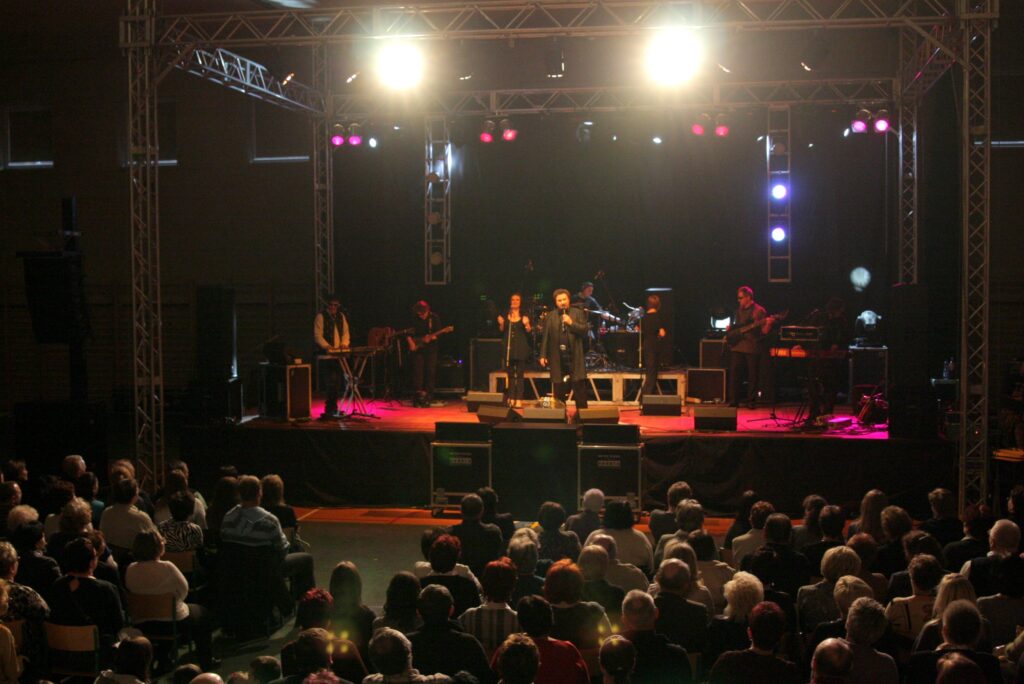 Krzysztof Krawczyk na scenie podczas koncertu w hali widowiskowej w Skokach 