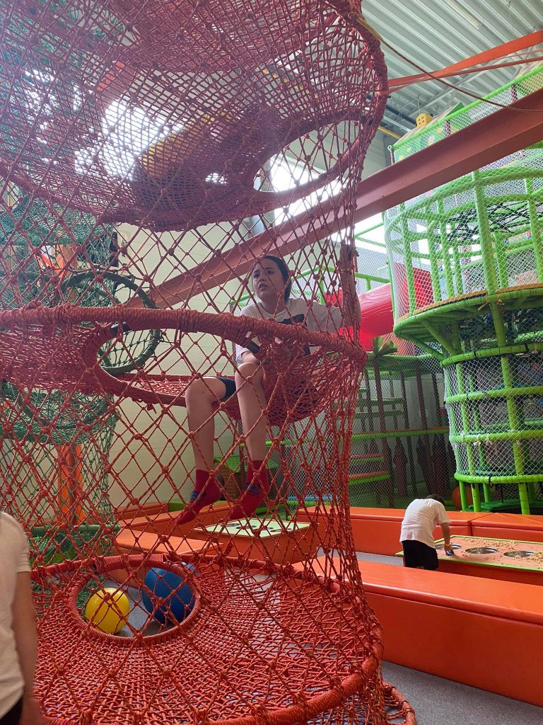 Uczennica Szkoły Podstawowej w Skokach na Jump Arenie, wspinająca się po podniebnych kokonach, przypominających pajęczą sieć