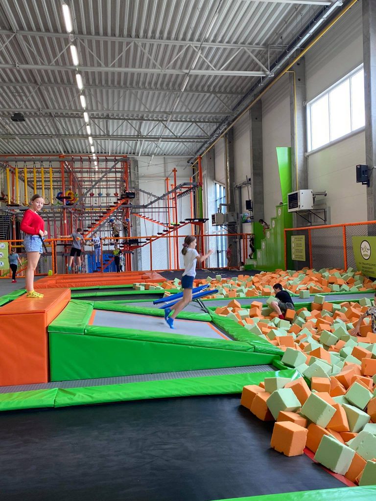 Uczennice Szkoły Podstawowej w Skokach na Jump Arenie w Poznaniu, oddają skok z trampoliny do basenu z gąbkami