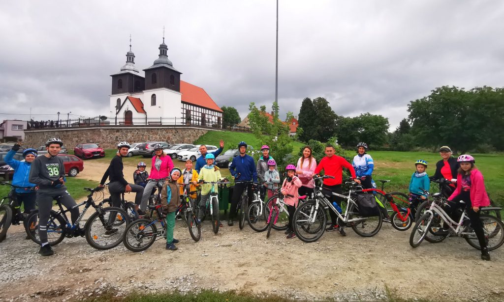 20 rowerzystów ustawiło się do wspólnego zdjęcia na tle kościoła w Skokach