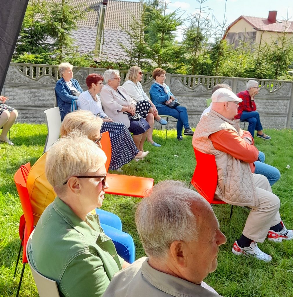 uczestnicy wydarzenia siedzą na widowni w plenerze 