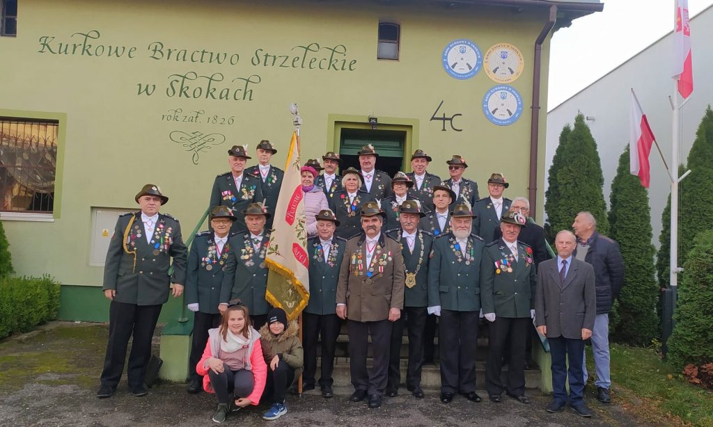 Bracia Kurkowi i zaproszeni goście pozują do wspólnego zdjęcia przed siedzibą bractwa 